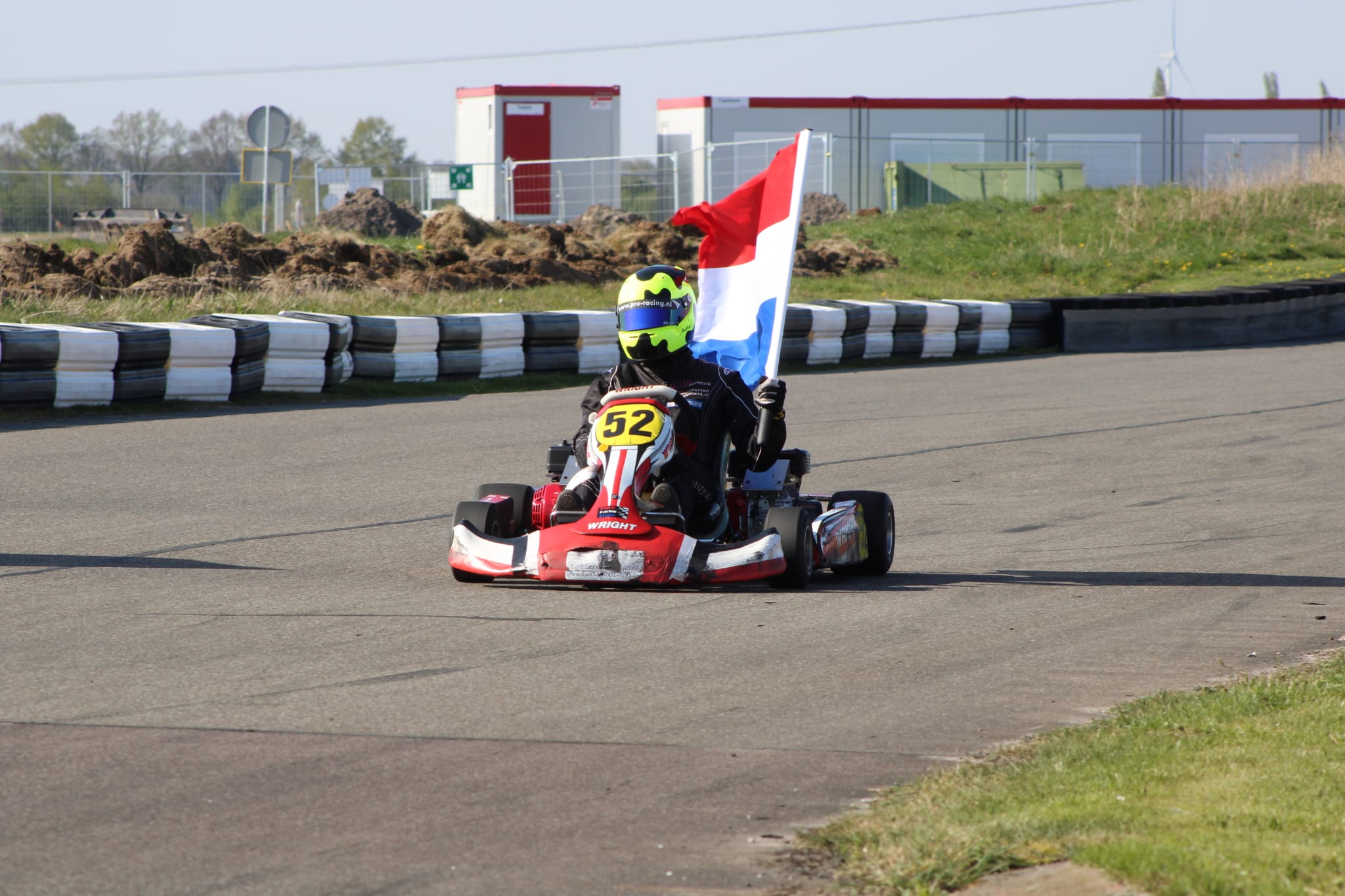 Maikel van Beek in prokart met Nederlandse vlag na winst